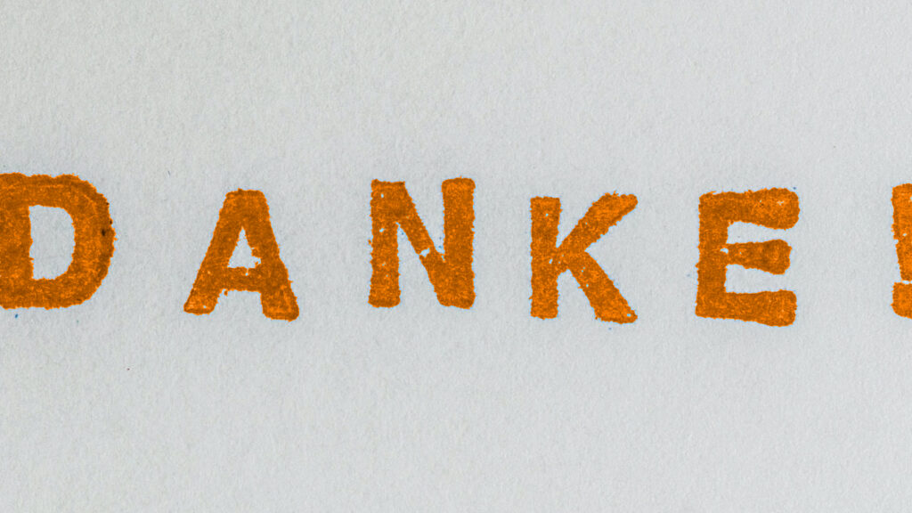 "Danke!" in orange auf Papier gestempelt