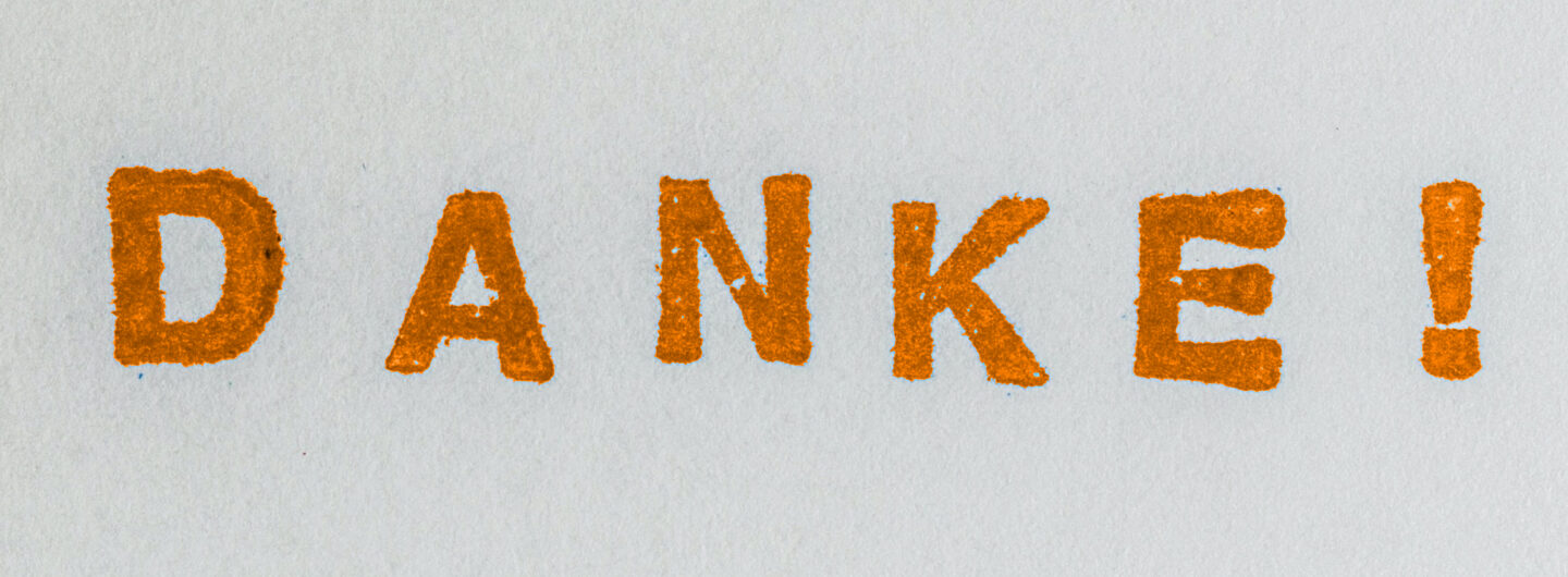 "Danke!" in orange auf Papier gestempelt
